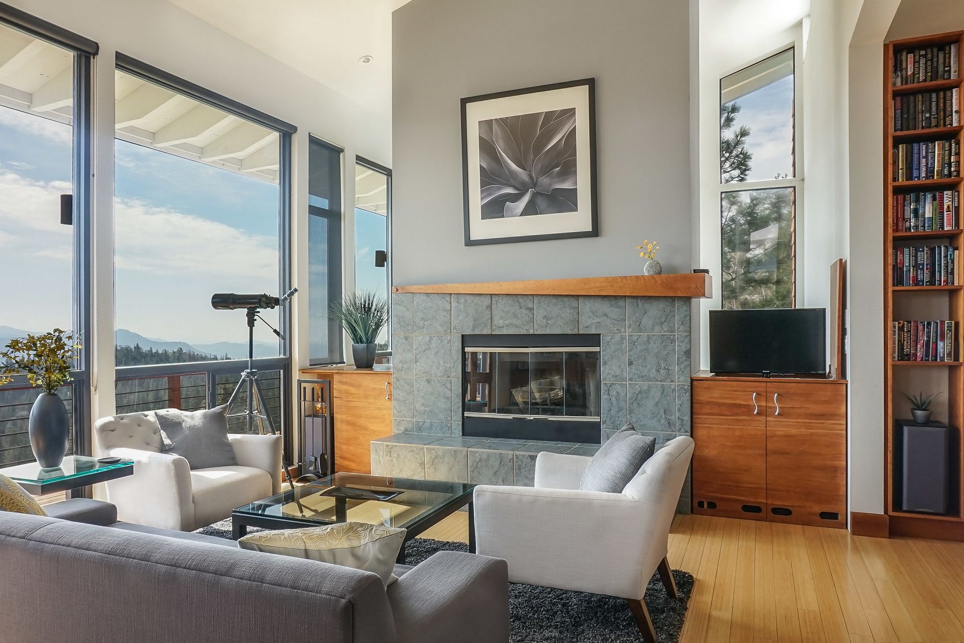 Bright hillside residence living room with floor-to-ceiling windows and mountain views
