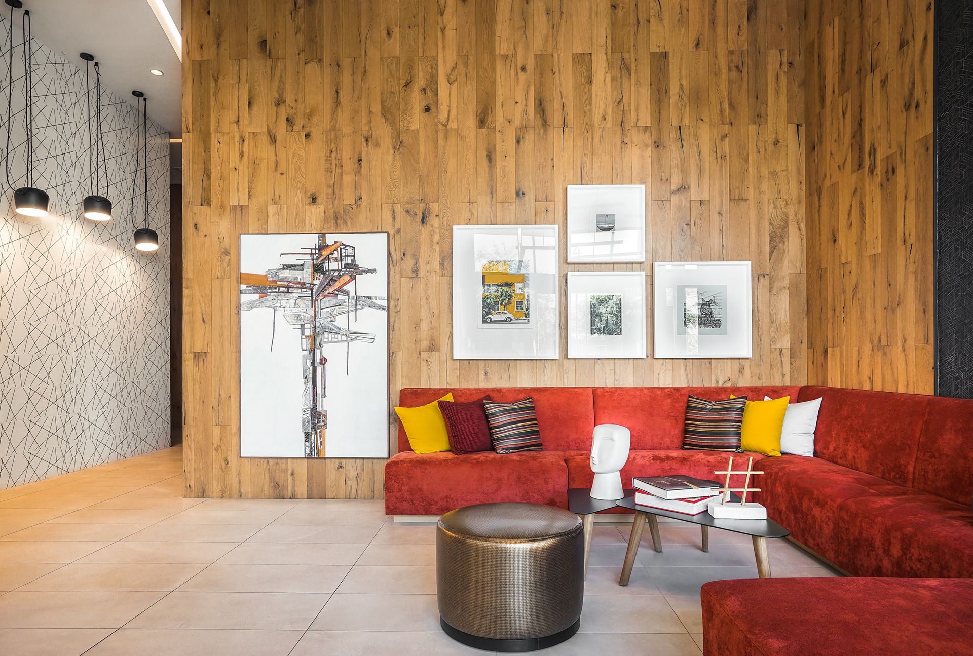 Boutique hotel lobby lounge with a red velvet sofa and framed gallery wall