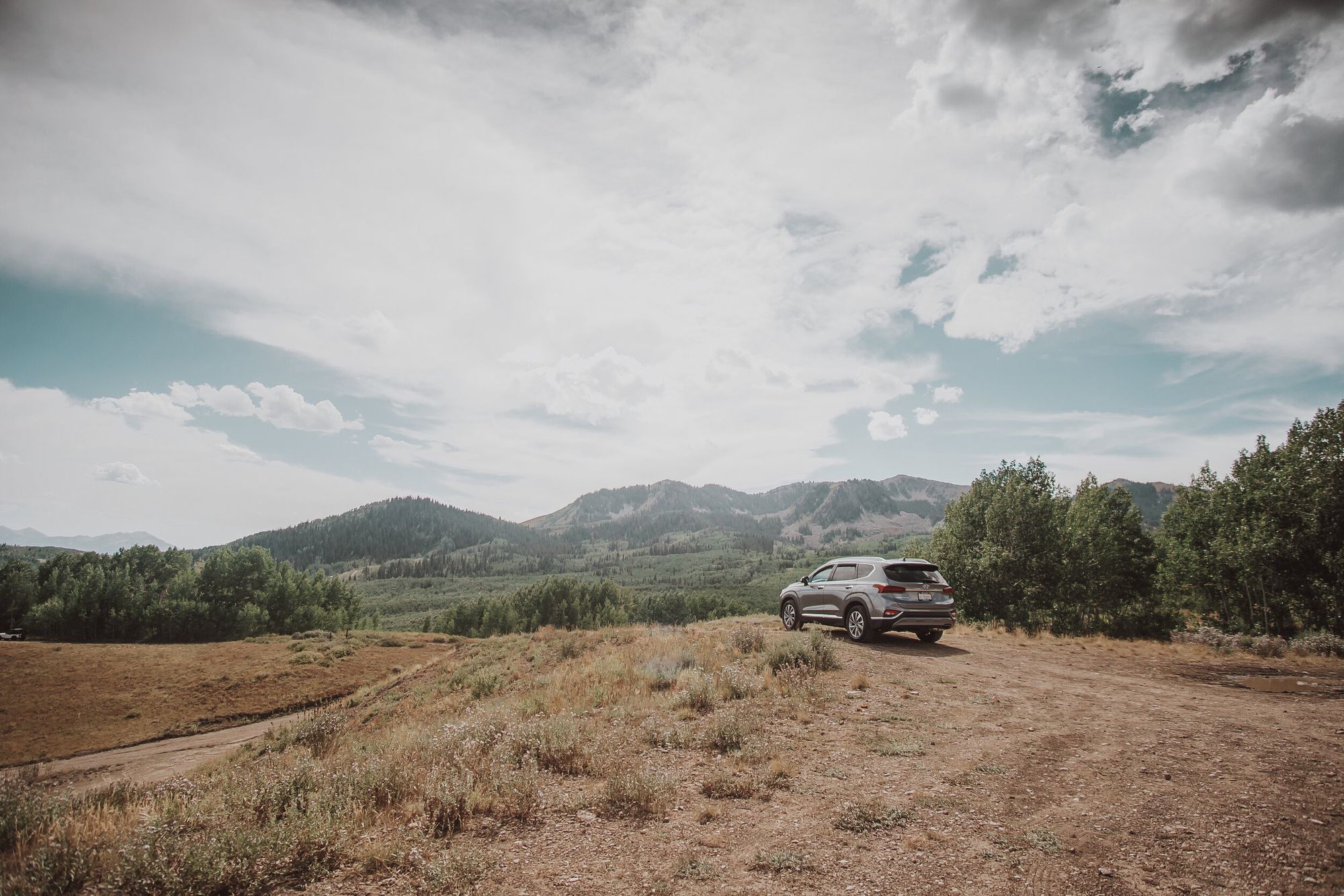 Hyundai Santa Fe parked on a ridge overlooking green mountains